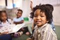 Portrait Of Smiling Male Elementary School Pupil Sitting In Classroom At  School Royalty Free Stock Photo