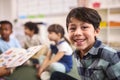 Portrait Of Smiling Male Elementary School Pupil Sitting In Classroom At  School Royalty Free Stock Photo