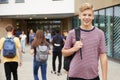 Portrait Of Smiling Male High School Student Outside College Building With Other Teenage Students In Background Royalty Free Stock Photo