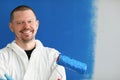 Portrait of smiling male house painter holding roller for painting walls