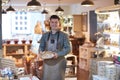 Portrait Of Smiling Male Owner Of Delicatessen Shop Wearing Apron Holding Loaf Of Bread Royalty Free Stock Photo