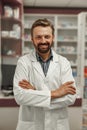 Portrait of smiling male pharmacist in white coat standing on pharmacy background Royalty Free Stock Photo