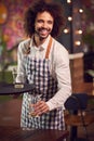 Portrait Of Smiling Male Server Clearing Table In Cool Bar Or Club