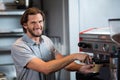 Portrait of smiling male staff making cup of coffee at counter