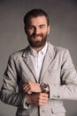 Portrait of smiling man with beard in white shirt and grey jacket isolated on gray studio background posing to the camera Royalty Free Stock Photo