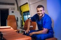 A portrait of a smiling man in a blue medical uniform sitting in the ambulance Royalty Free Stock Photo