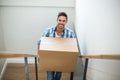 Portrait of smiling man holding cardboard box while climbing steps