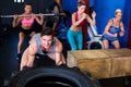 Portrait of smiling man lifting tire in gym Royalty Free Stock Photo