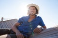 Portrait of smiling man relaxing on hammock at beach Royalty Free Stock Photo