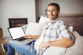 Portrait of smiling man using laptop at home Royalty Free Stock Photo