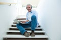 Portrait of smiling man using laptop on steps Royalty Free Stock Photo