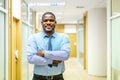 Portrait of smiling mature african american executive businessman in suit looking at camera while with arms crossed Royalty Free Stock Photo