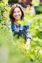 Portrait of smiling mature beautiful shop owner standing against plants