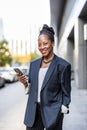 Smiling mature businesswoman using mobile phone in urban setting Royalty Free Stock Photo