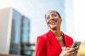 Smiling mature businesswoman using mobile phone in urban setting Royalty Free Stock Photo