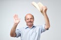 Portrait of a smiling mature european man putting cowboy hat off and looking at camera. I am waiting to hear from you Royalty Free Stock Photo