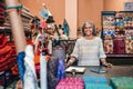 Smiling mature woman working in her colorful fabric shop Royalty Free Stock Photo