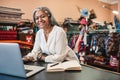 Smiling woman working on a laptop in her textiles store Royalty Free Stock Photo