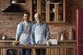 Portrait smiling mature father with grownup son standing in kitchen Royalty Free Stock Photo