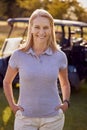 Portrait Of Smiling Mature Female Golfer Standing By Buggy On Golf Course Royalty Free Stock Photo