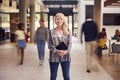 Portrait Of Smiling Mature Female Tutor In Busy University Or College Building With Students Royalty Free Stock Photo