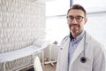 Portrait Of Smiling Mature Male Doctor Wearing White Coat With Stethoscope Standing In Office Royalty Free Stock Photo