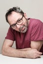 Portrait of a smiling mature with beard wearing red t-shirt and glasses Royalty Free Stock Photo