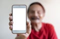 Portrait of smiling mature man holding smartphone with white blank screen in hand Royalty Free Stock Photo