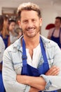 Portrait Of Smiling Mature Man Wearing Apron Taking Part In Cookery Class In Kitchen