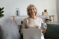 Portrait smiling mature woman enjoying leisure time, using laptop Royalty Free Stock Photo