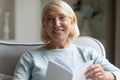 Portrait of smiling mature woman reading book at home Royalty Free Stock Photo