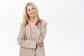 Portrait of smiling mature woman, 50 years old grandmother, standing in trench coat, looking happy, standing over white Royalty Free Stock Photo