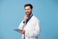 Portrait of smiling medical specialist in white coat standing with clipboard in hands Royalty Free Stock Photo