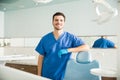 Portrait Of Smiling Dentist Standing By Chair At Clinic Royalty Free Stock Photo