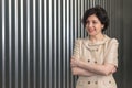 Portrait of smiling middle aged business woman with crossed arms on a striped wall background. Royalty Free Stock Photo