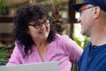 Portrait of smiling middle-aged couple. Man sitting at table in cafe park, having fun with curly happy joyful woman. Royalty Free Stock Photo