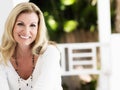 Portrait of a smiling middle aged woman sitting on verandah Royalty Free Stock Photo