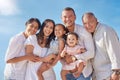 Portrait of smiling mixed race family with little girls standing together on beach. Adorable little kids bonding with Royalty Free Stock Photo