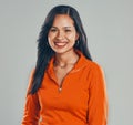 Portrait of smiling mixed race woman isolated against grey studio background with copyspace. Beautiful young hispanic Royalty Free Stock Photo