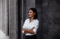 Portrait of a Smiling Mixed Races Business Woman, Crossed Arm and Looking away in City Royalty Free Stock Photo