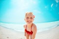 Portrait of smiling modern child in red beachwear on seacoast