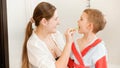 Portrait of smiling mother brushing teeth of her little son in bathroom. Concept of child hygiene and healthcare at home Royalty Free Stock Photo