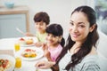 Portrait of smiling mother with children at dining table Royalty Free Stock Photo