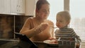 Portrait of smiling mother feeding her little baby son with soup. Domestic food, cooking at home, children healthy nutrition Royalty Free Stock Photo