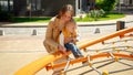 Portrait of smiling mother helping her baby son climbing on the playground. Children playing outdoor, kids outside, summer holiday Royalty Free Stock Photo