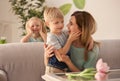 Portrait of smiling mother and her cute little children at home Royalty Free Stock Photo