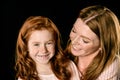 Portrait of smiling mother looking at adorable redhead daughter