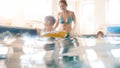 Portrait of happy smiling mother with 3 years old little son swimming in the pool at gym. Family raelaxing, having fun Royalty Free Stock Photo