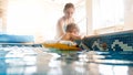 Portrait of happy smiling mother with 3 years old little son swimming in the pool at gym. Family raelaxing, having fun Royalty Free Stock Photo