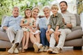 Portrait of a smiling multi generation caucasian family sitting close together on the sofa at home. Happy adorable Royalty Free Stock Photo
